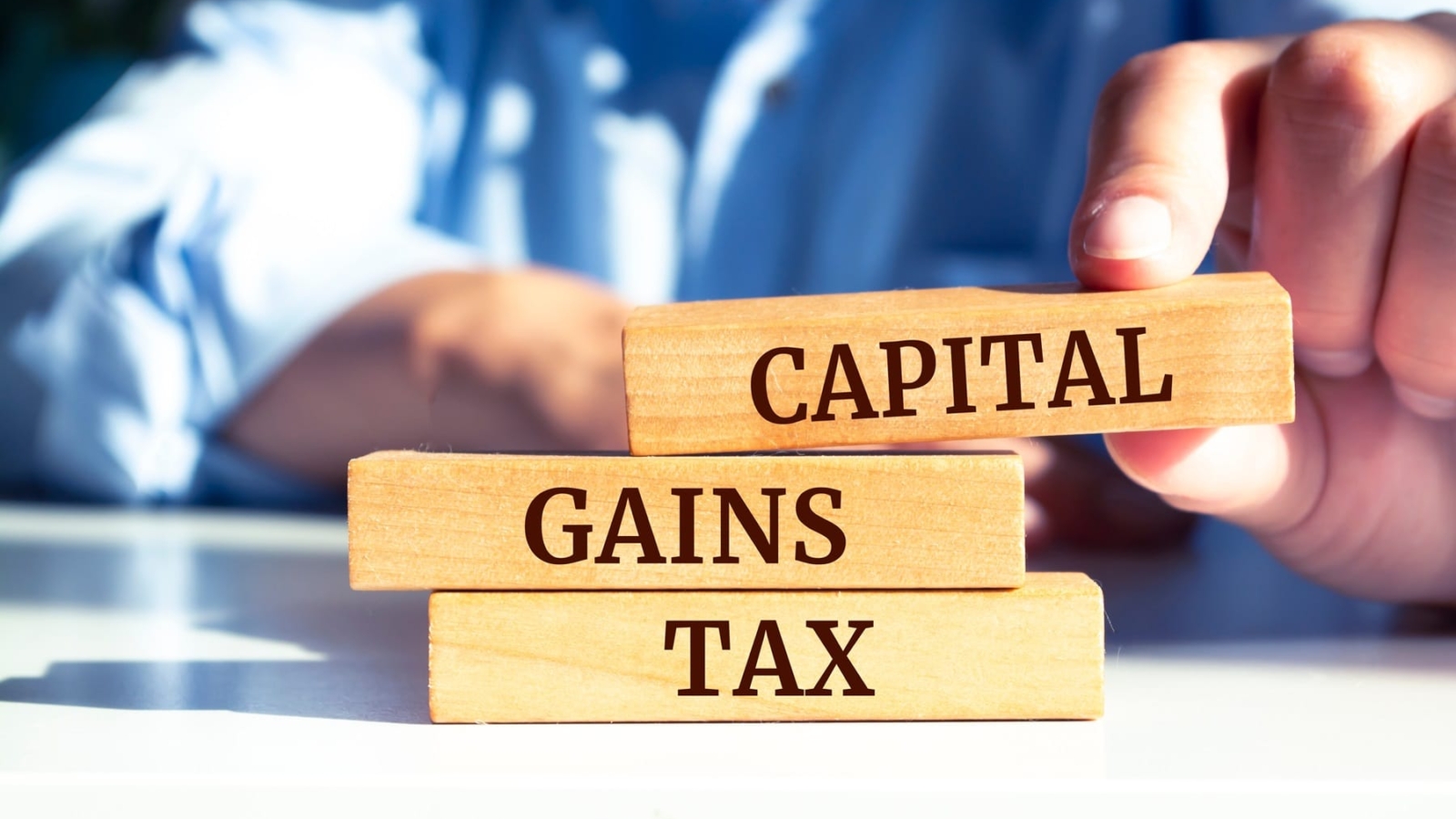 Close,Up,On,Businessman,Holding,A,Wooden,Block,With,"capital